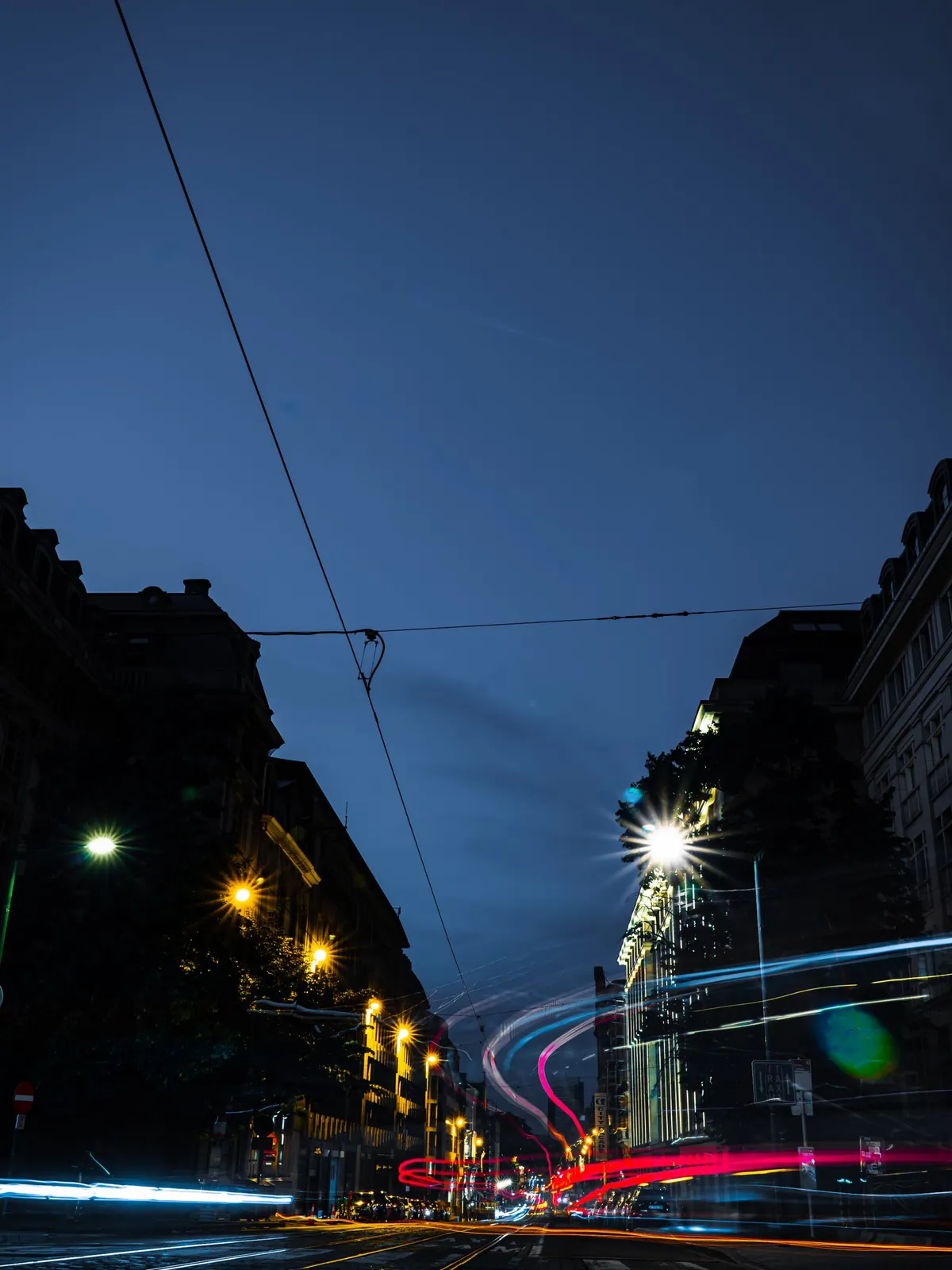 Lange belichting van een Brusselse straat met blauwe, rode en gele lichtsporen
