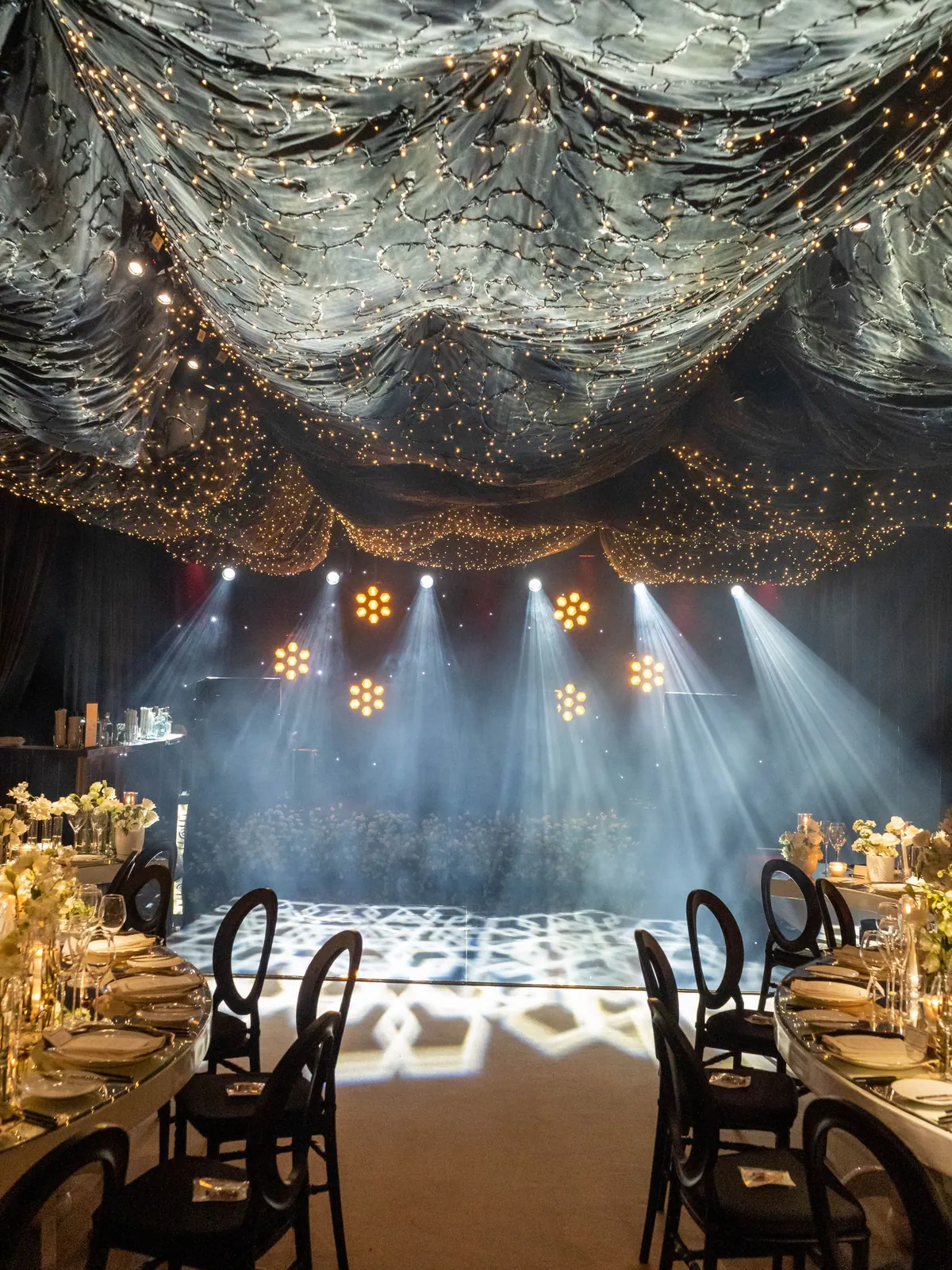 Premium evenementenruimte met fonkelende lichtinstallatie en gedekte tafels